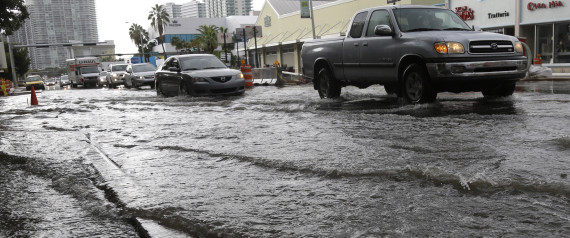Vehicles negotiate heavily flooded streets as rain falls, Tuesday, Sept. 23, 2014, in Miami Beach, Fla. Certain neighborhoods regularly experience flooding during heavy rains and extreme high tides. New storm water pumps are currently being installed along the bay front in Miami Beach. National and regional climate change risk assessments have used the flooding to illustrate the Miami area's vulnerability to rising sea levels. ASSOCIATED PRESS